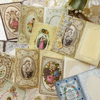 Vintage lace memo pads with religious portraits and floral borders scattered for bullet journaling