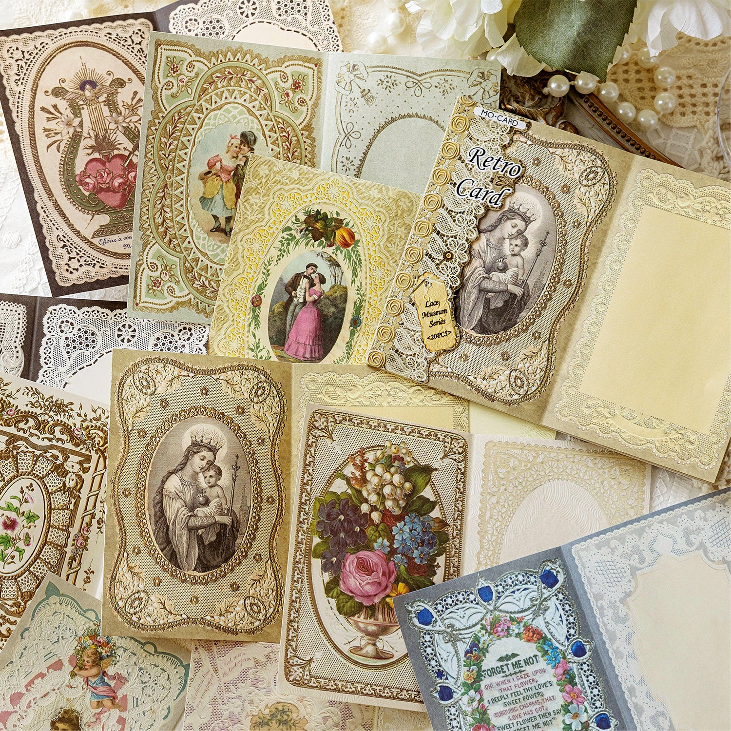 Vintage lace memo pads with religious portraits and floral borders scattered for bullet journaling