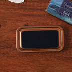 Vintage iron box ink pad in Voyage Blue open on wood, navy sea lid beside