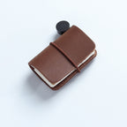Tan waxed leather mini traveler's notebook charm with elastic band and vintage metal clasp