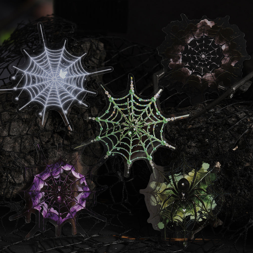 Glowing spider web stickers — white, green and violet — on a dark moody background
