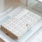 White tweed journal lying flat on a desk showing Timeless Wardrobe cover text
