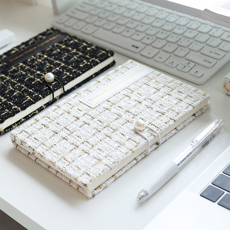 White tweed grid journal open beside a keyboard, showing 5mm grid pages