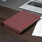 	Wine red B5 leather ring binder journal closed on wooden desk