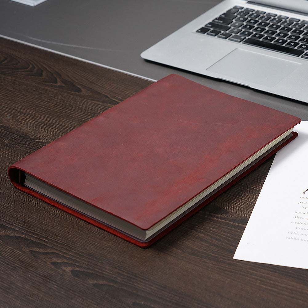 	Wine red B5 leather ring binder journal closed on wooden desk