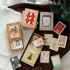 Christmas letter sticker box in Winter Cedar style with gold embossed stickers scattered on a wooden tray