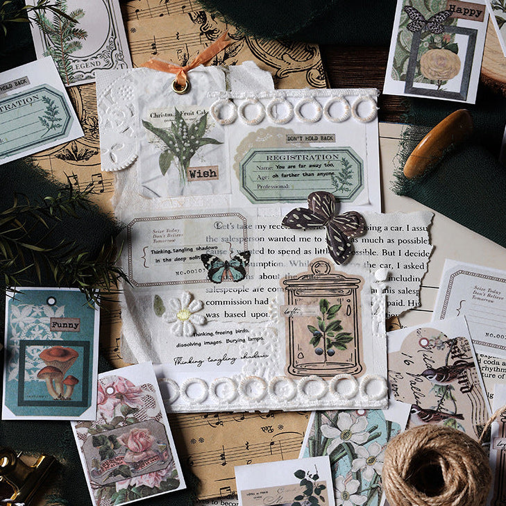 Woodland Walk vintage washi sticker book with green forest-themed illustrations displayed on botanical paper with fern and pressed flower accents