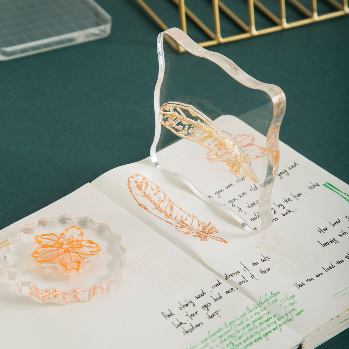 Clear acrylic stamp block pressing a floral stamp onto paper – transparent mounting plate for precise placement