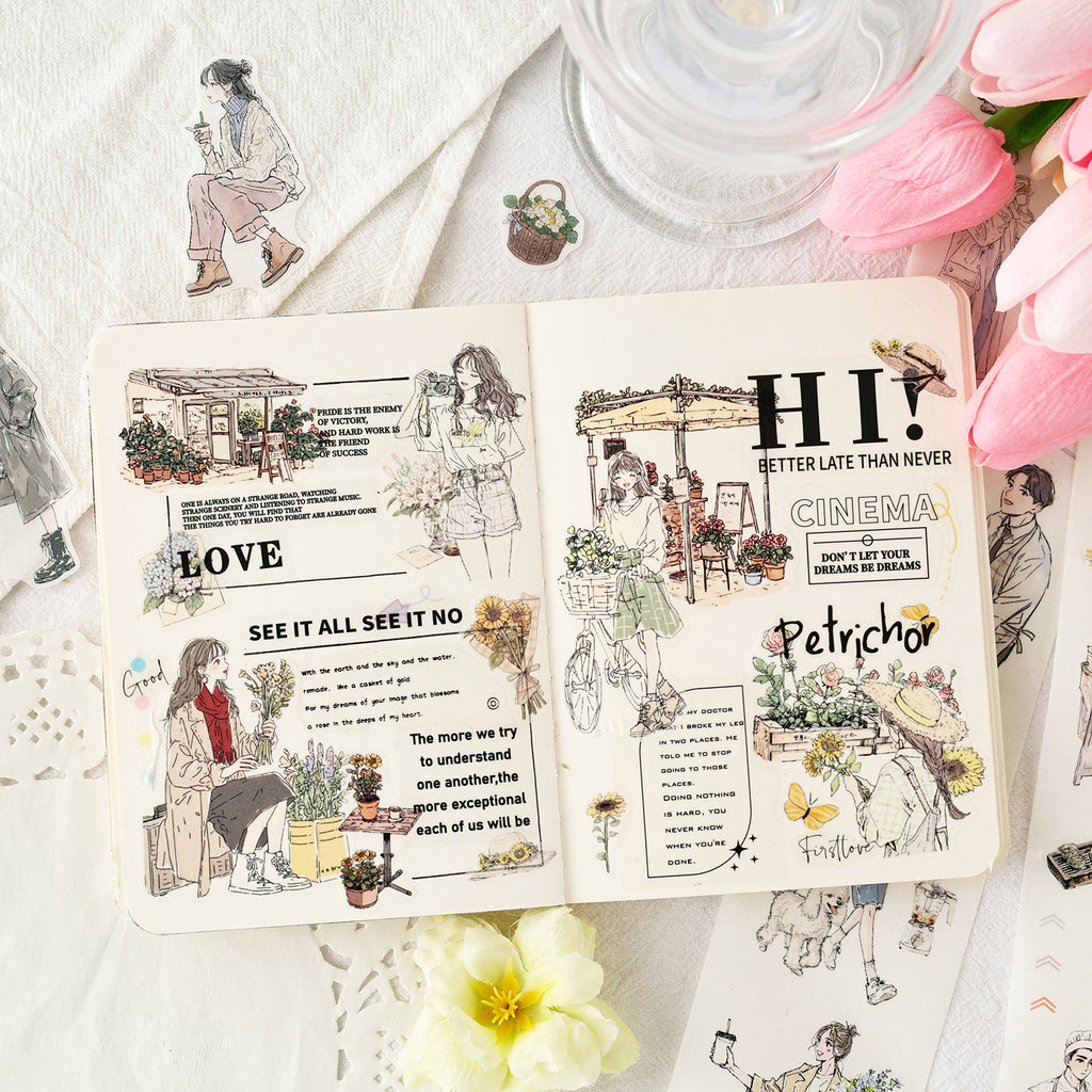 A creative bullet journal spread inspiration using the aesthetic character die-cut washi tape. Showcases beautifully layered lifestyle illustrations of girls, bicycles, and blooming flowers, surrounded by pink tulips on a desk.