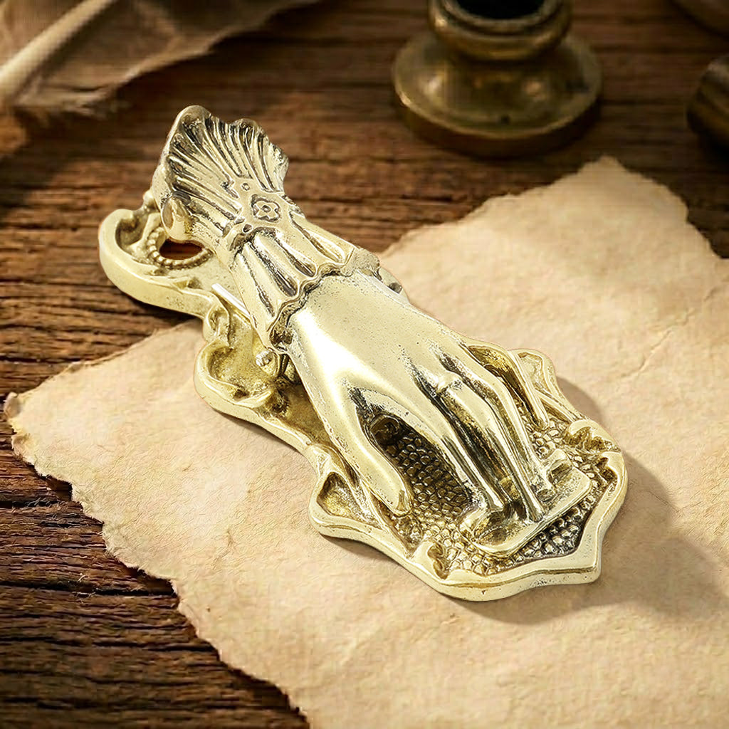 A deep, oxidized aged antique bronze metal journal clip, styled as a Victorian Lady's Hand without a pearl. The dark bronze finish has a heavy patina, perfect for dark gothic and industrial aesthetics. It is holding down a collection of dark and distressed ephemera and aged maps.