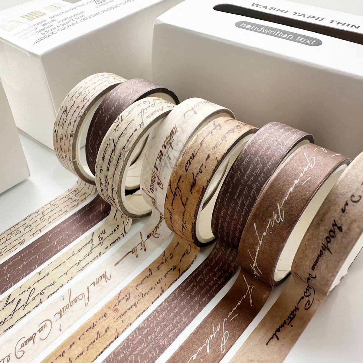 Close-up of the Antique Script vintage slim washi tape set, featuring 8 rolls of sepia-toned handwritten letter patterns unrolled next to its white box, ideal for Dark Academia journaling.