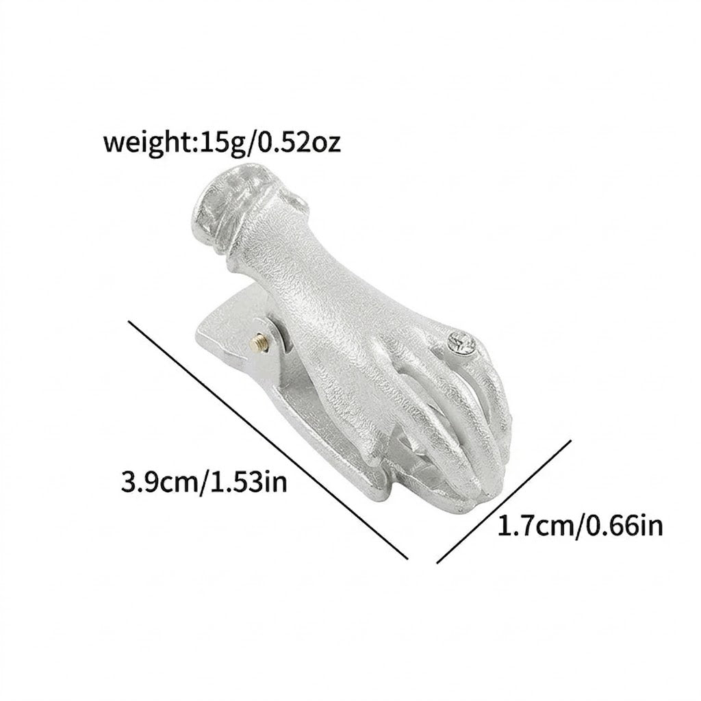 An antique silver metal clip shaped like a small hand holding a detailed rose bouquet (no pearl detail). A clear rhinestone ring is on the finger, clamping lightly aged script paper. Ideal for vintage scrapbooking and page holding.