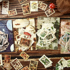 Starry night postage stamp stickers spread on rustic wood – moon phases and constellation designs with postmark details