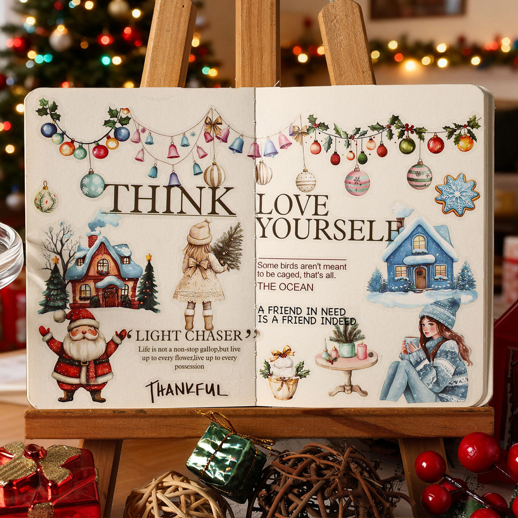 Christmas Carol stickers arranged on a journal spread with warm fairy lights