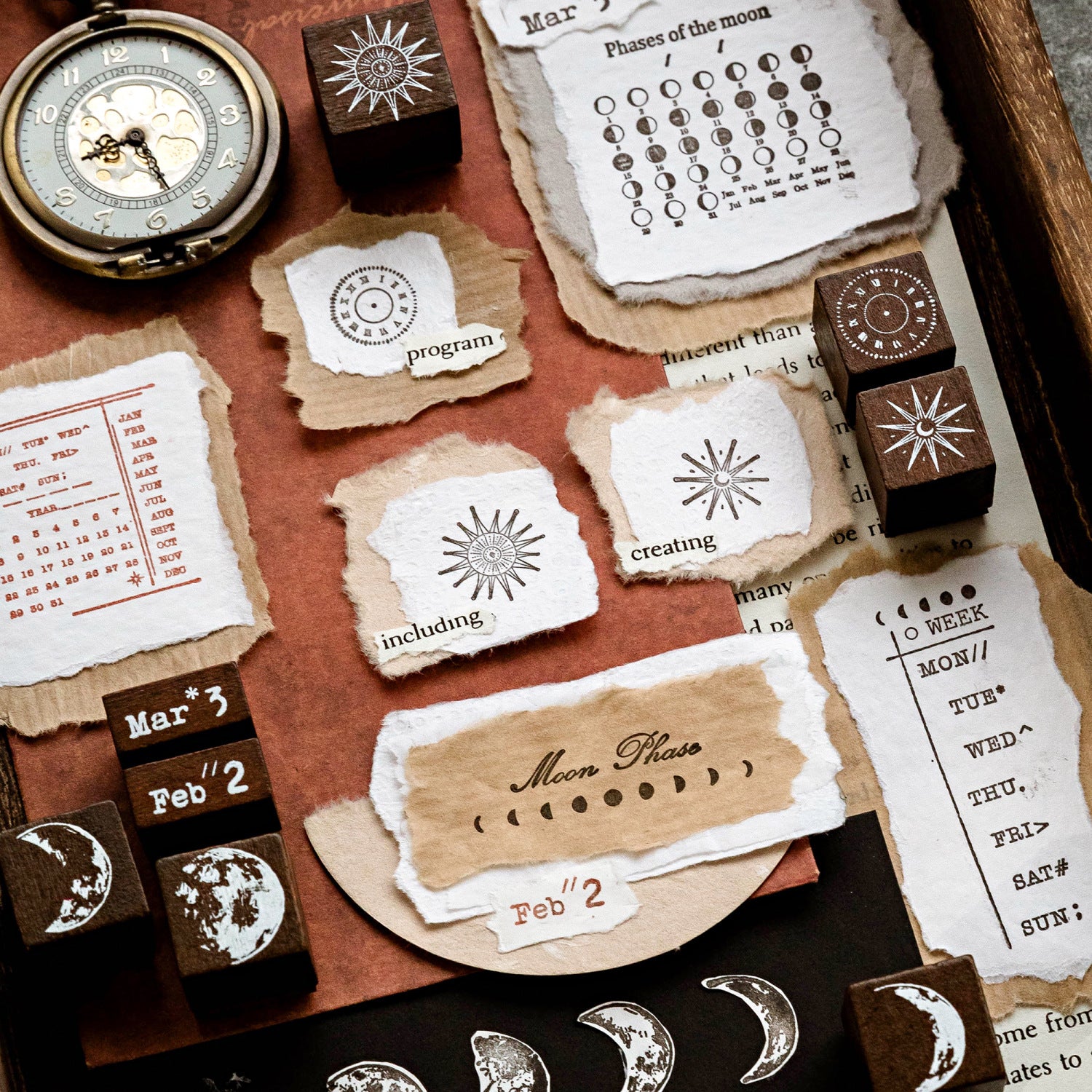 Aesthetic bullet journal layout featuring circular moon phase tracker stamps applied to round pastel papers. Surrounded by celestial solid wood stamps, a vintage pocket watch, and dark academia ephemera.