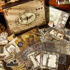 Aesthetic flat lay of the vintage journaling kit contents. Features translucent vellum papers, antique ticket stubs, and the stunning moth illustration gift box styled with a classic pocket watch.