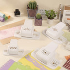 White border punch collection on desk with cactus ink bottle and pastel paper strips