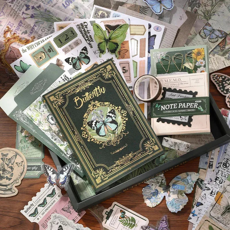 Comprehensive flat lay showcasing the 140-piece Emerald Forest botanical green journaling kit. The collection features a butterfly cover A6 notebook, green memo papers, gold clips, vintage ephemera, and PET butterfly stickers for Cottagecore crafting.