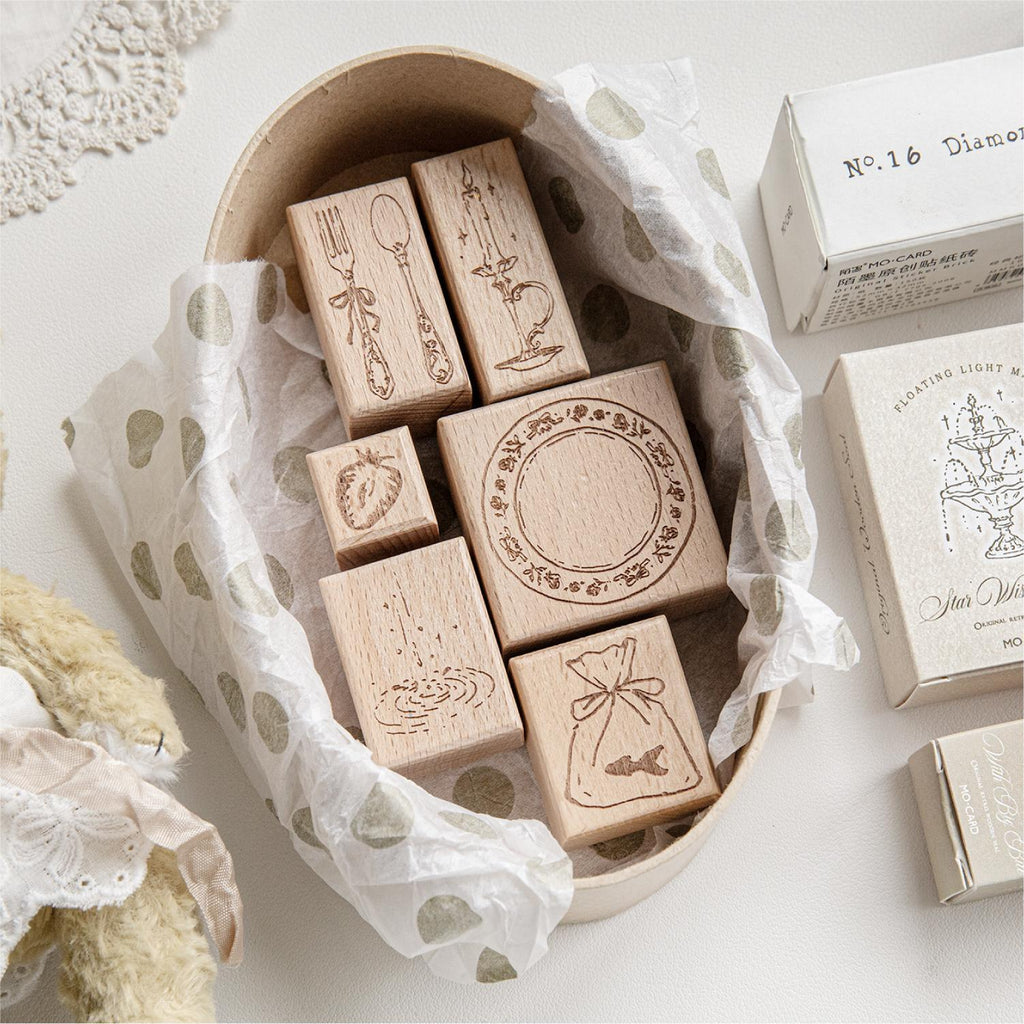 Floating Light Imprint wooden stamps arranged in a woven basket with gift boxes