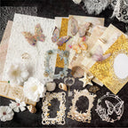 Flat lay of the Gilded Sands premium mixed media ephemera kit. Showcases elegant white 3D faux flowers, holographic PET butterflies, gold mesh, seashells, and intricate laser-cut frames on a dark background.