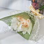 Sage green fishnet overlay paper wrapping a white flower bouquet with ribbon