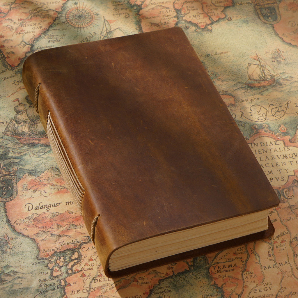 Brown crazy horse leather sketchbook closed on vintage world map