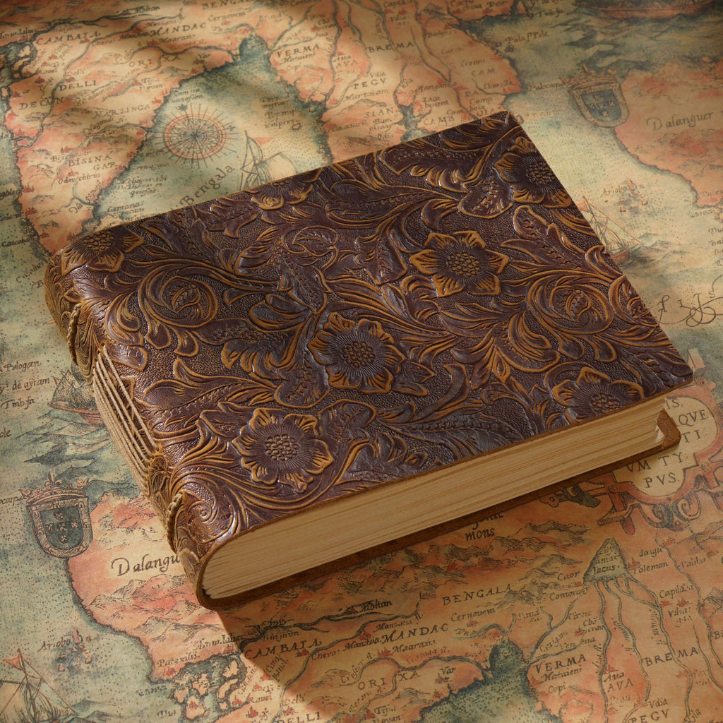 Dark vintage leather sketchbook top view on antique map