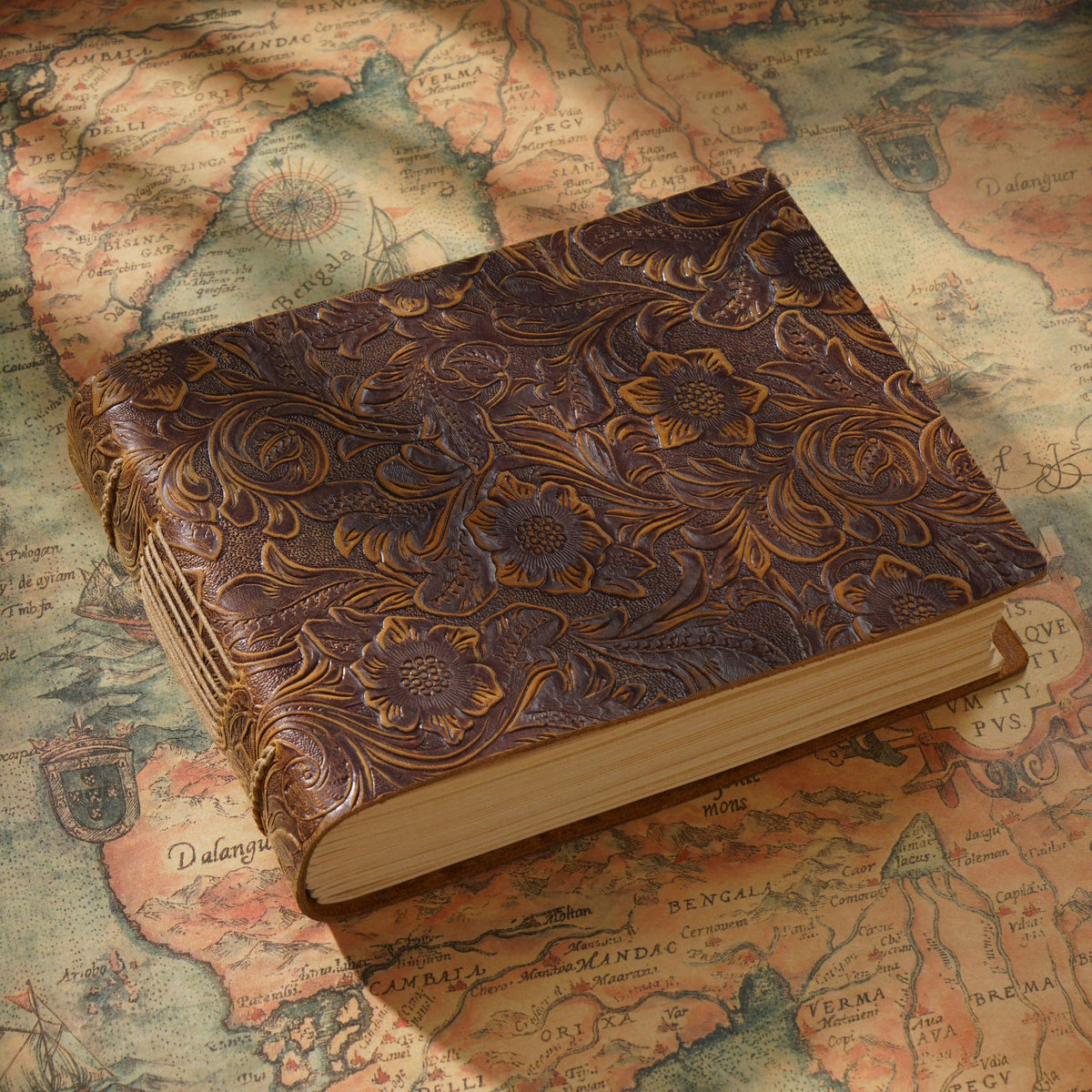 Dark vintage leather sketchbook top view on antique map