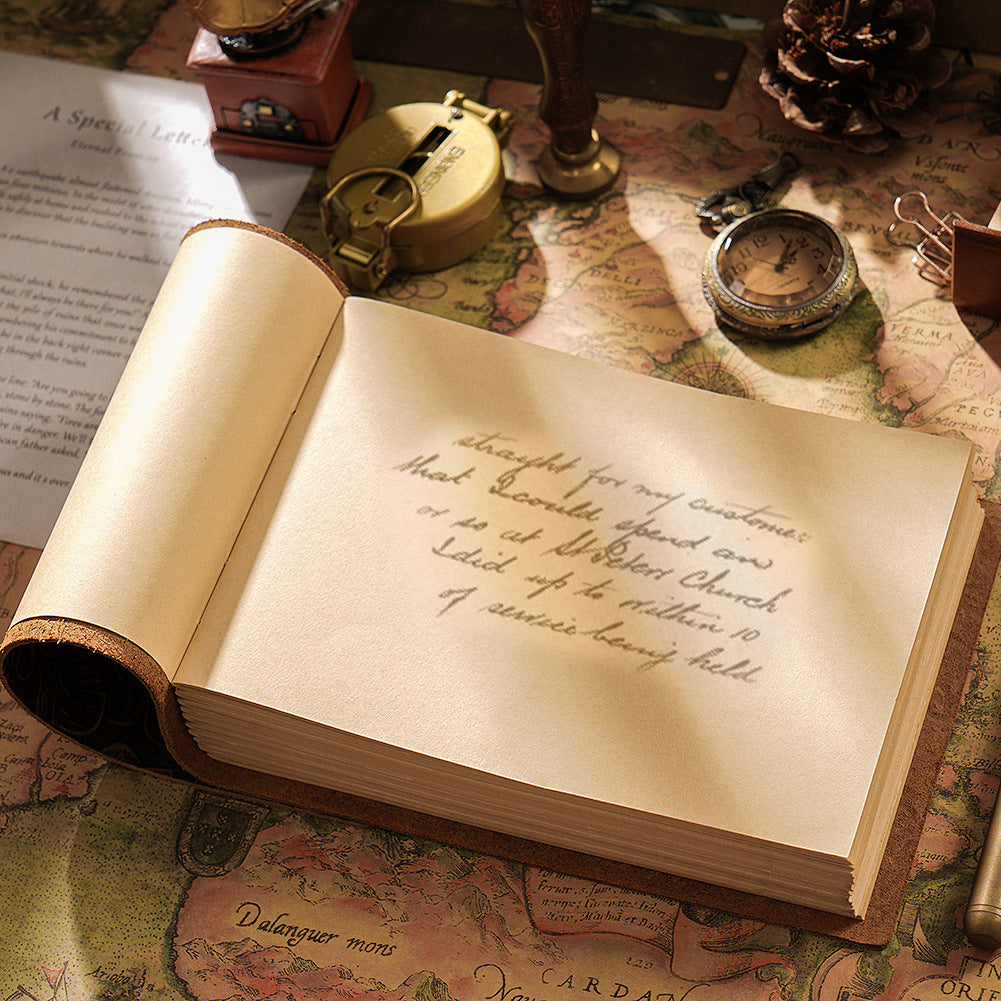 Open leather sketchbook with handwritten journal entry and brass compass