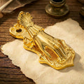 A luminous gold Victorian Lady's Hand metal journal clip clamping aged paper with typed text, on a soft blurred background of vintage ephemera.