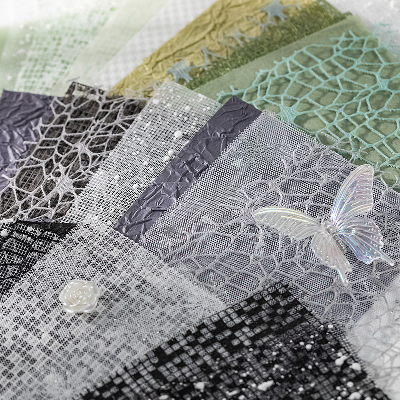 Close-up of layered fishnet, mesh, and sequin textured specialty papers in grey and green