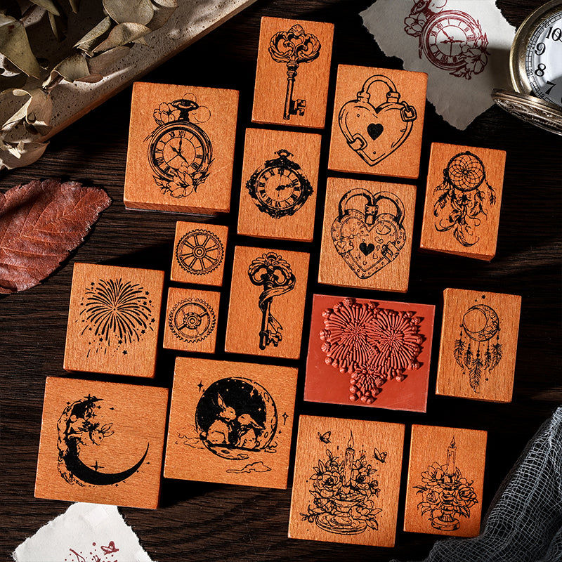 A flat lay of 16 solid beech wood stamps scattered on a desk. Showcases the deep-etched red rubber bases and intricate fairy tale designs like vintage keys, moons, and floral candles.