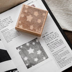 Star grid romantic background stamp on open magazine page, geometric dot pattern printed in black ink.