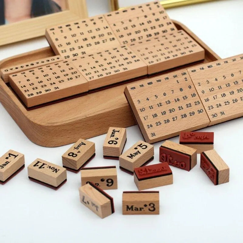 Close-up of scattered solid wood month stamps and large date grid blocks from the perpetual calendar set, perfect for creating quick vintage scrapbooking layouts.
