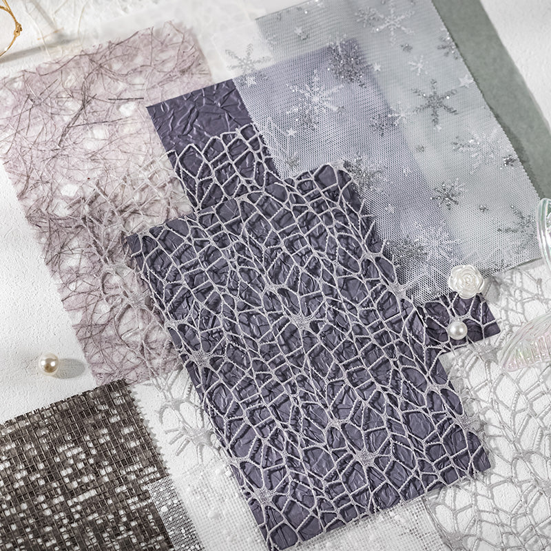Slate grey and purple fishnet, crinkle, and snowflake mesh paper flatlay arrangement