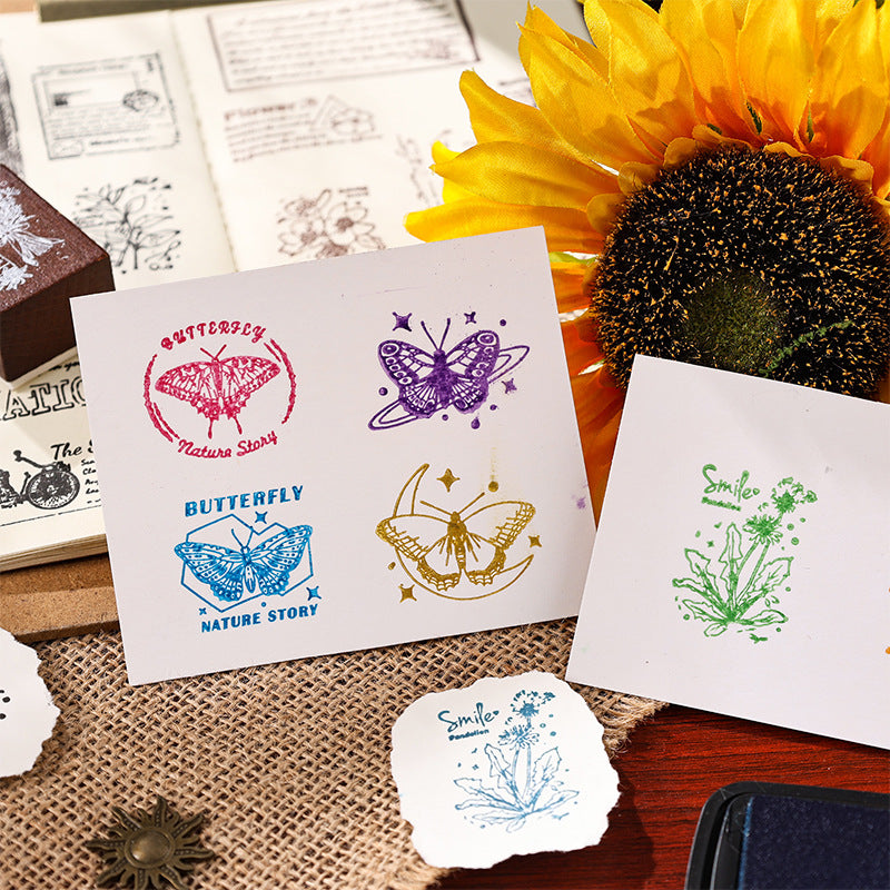 Hands stamping butterfly and diamond impressions onto white cards