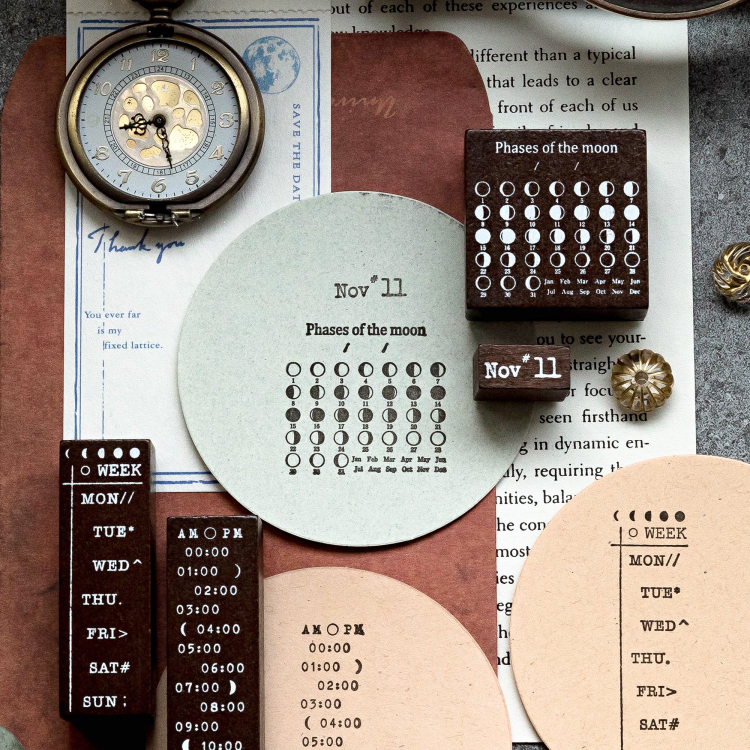 Creative junk journal layering using the celestial stamp set. Features crisp sunburst and moon phase impressions on torn edges of kraft paper and vintage book pages, styled beautifully with a bronze pocket watch.