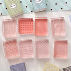 Textured acrylic stamp blocks flat lay – clear patterned stamping surfaces in pink and blush tones
