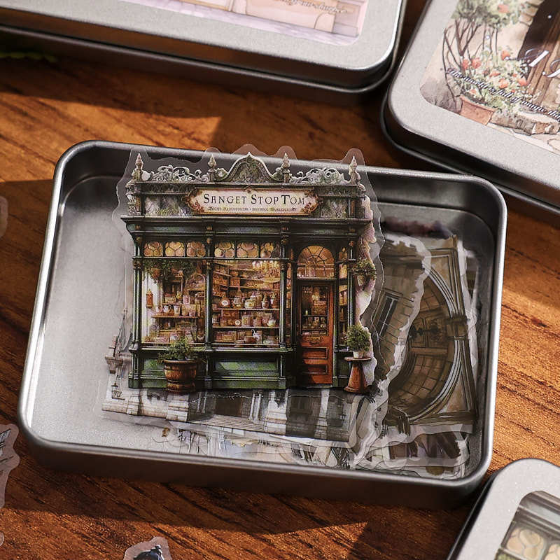 Open travelogue sticker tin showing European street scene PET stickers – die-cut cityscape designs in a reusable tin
