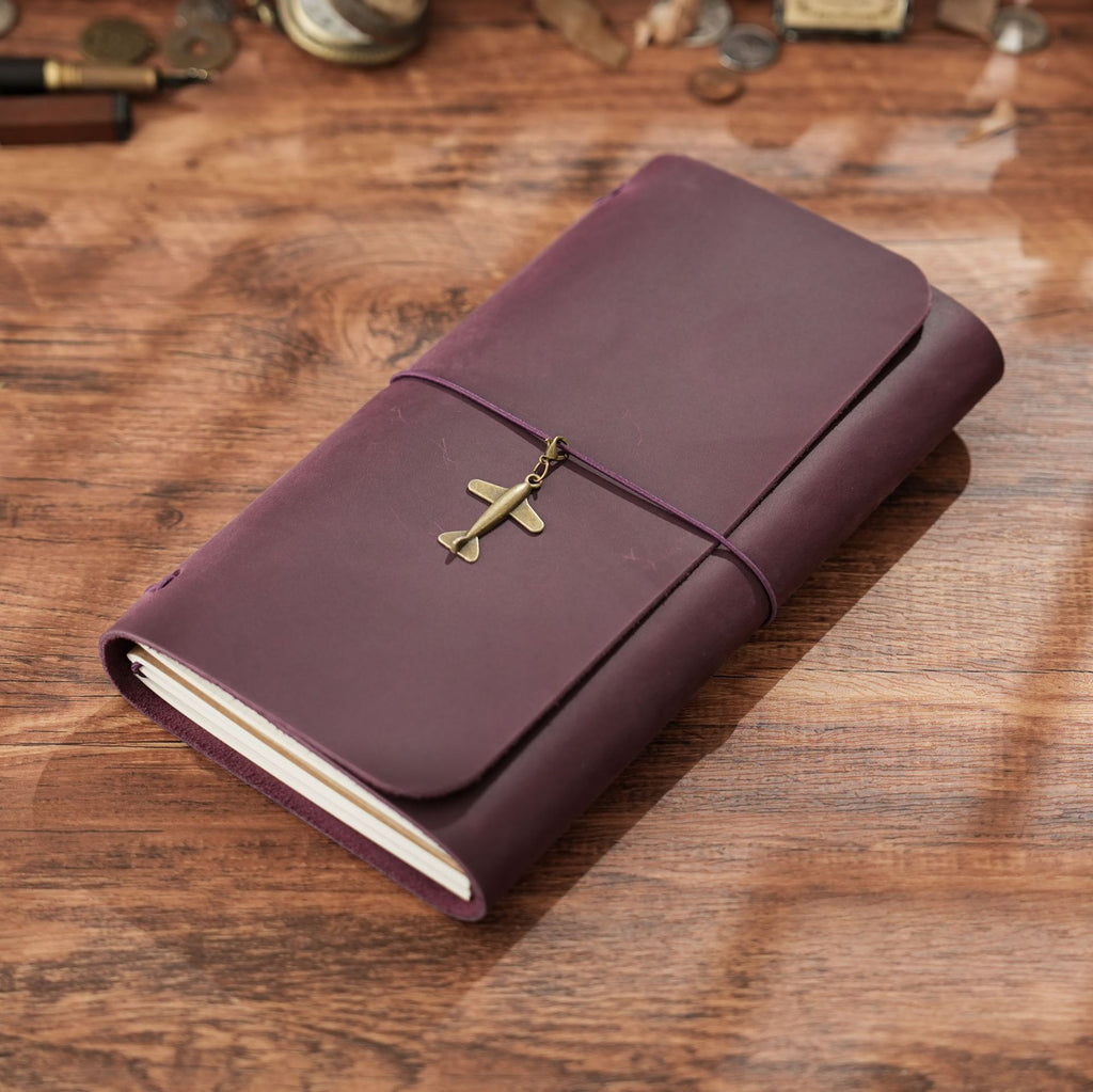 Dark purple trifold leather notebook with brass charm and elastic band