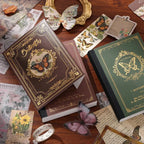 Close-up of the premium A6 hardcover notebooks from the vintage butterfly journal kit. Shows the Nature's Whispers brown cover with an intricate gold foil frame and the Emerald Forest green cover, beautifully displayed with translucent butterfly stickers.