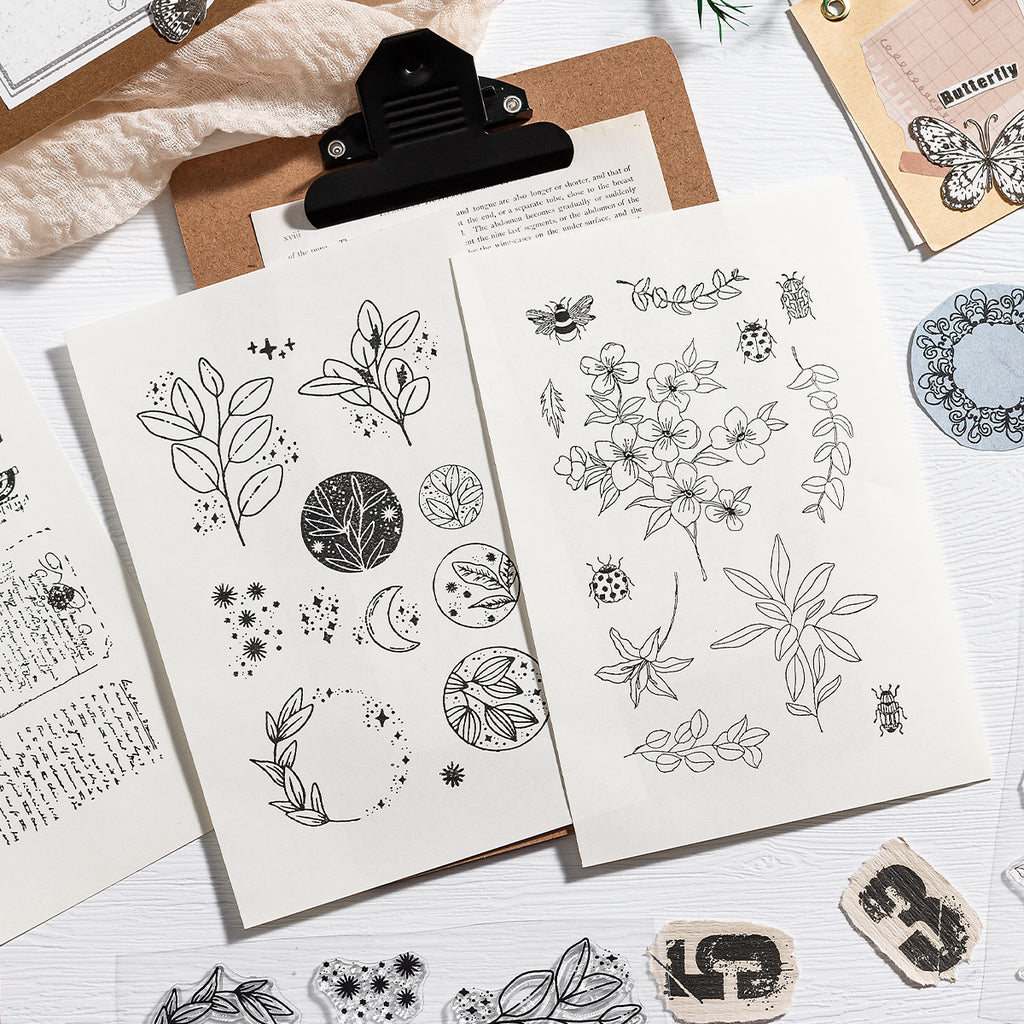 Vintage clear stamp sheet on a clipboard with stamped botanical impressions – journaling supplies flat lay
