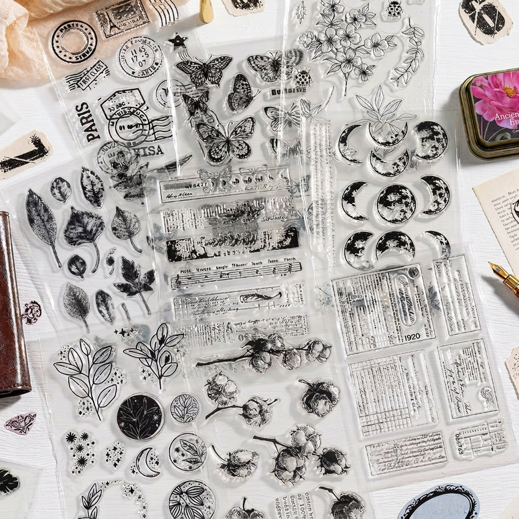 Stamped impressions from vintage clear stamps – script text, butterflies and botanical designs in black ink