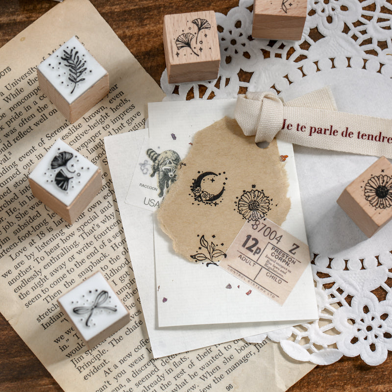 Aesthetic junk journal layering using the botanical wooden stamps. Features crisp floral and leaf impressions on torn kraft paper and vintage ephemera with a lace background.
