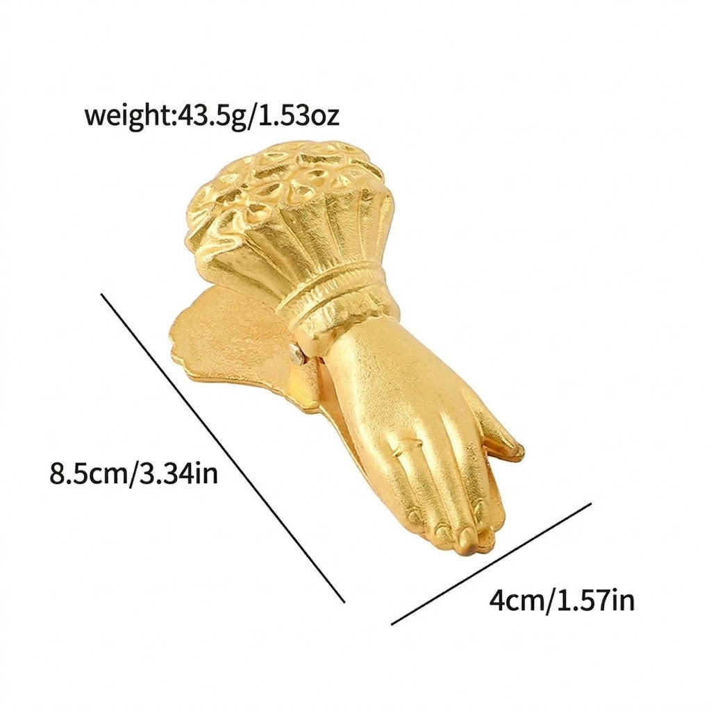A heavy-duty vintage gold metal journal clamp in the form of a substantial hand holding large rose bouquets (no pearl detail). Features a clear rhinestone ring on the finger, designed for securing thick paper stacks in mixed media journaling.