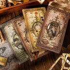 A stack of the four vintage hardcover notebooks available in the journaling kit. Each cover features intricate Victorian-era designs, including antique typewriters, pocket watches, and classic typography.