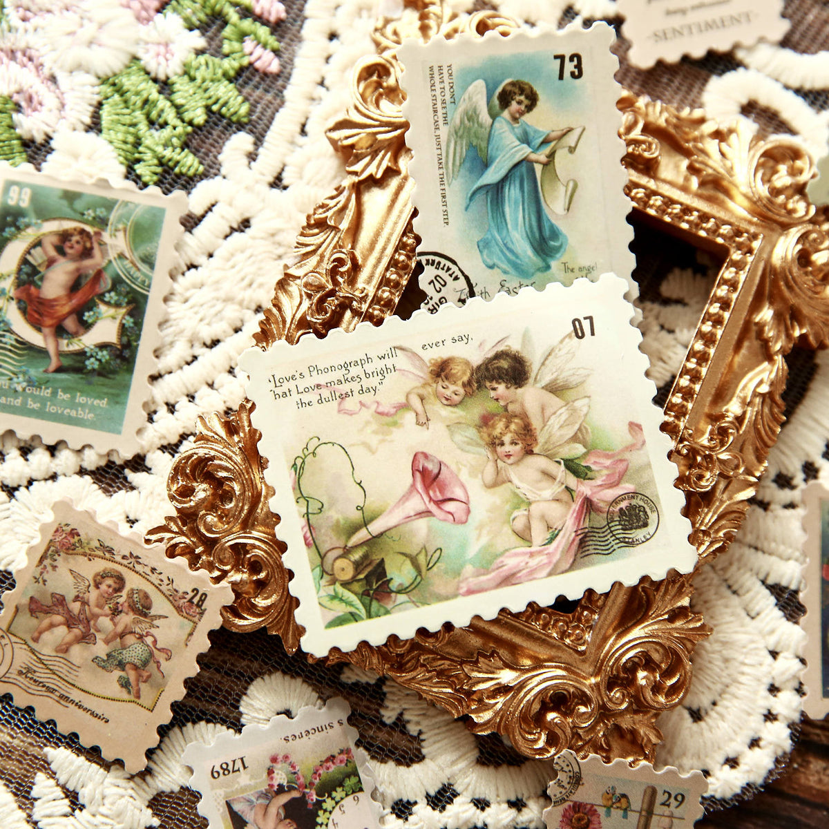 Vintage angel postage stamp stickers arranged with lace doilies – celestial cherub designs on aged paper