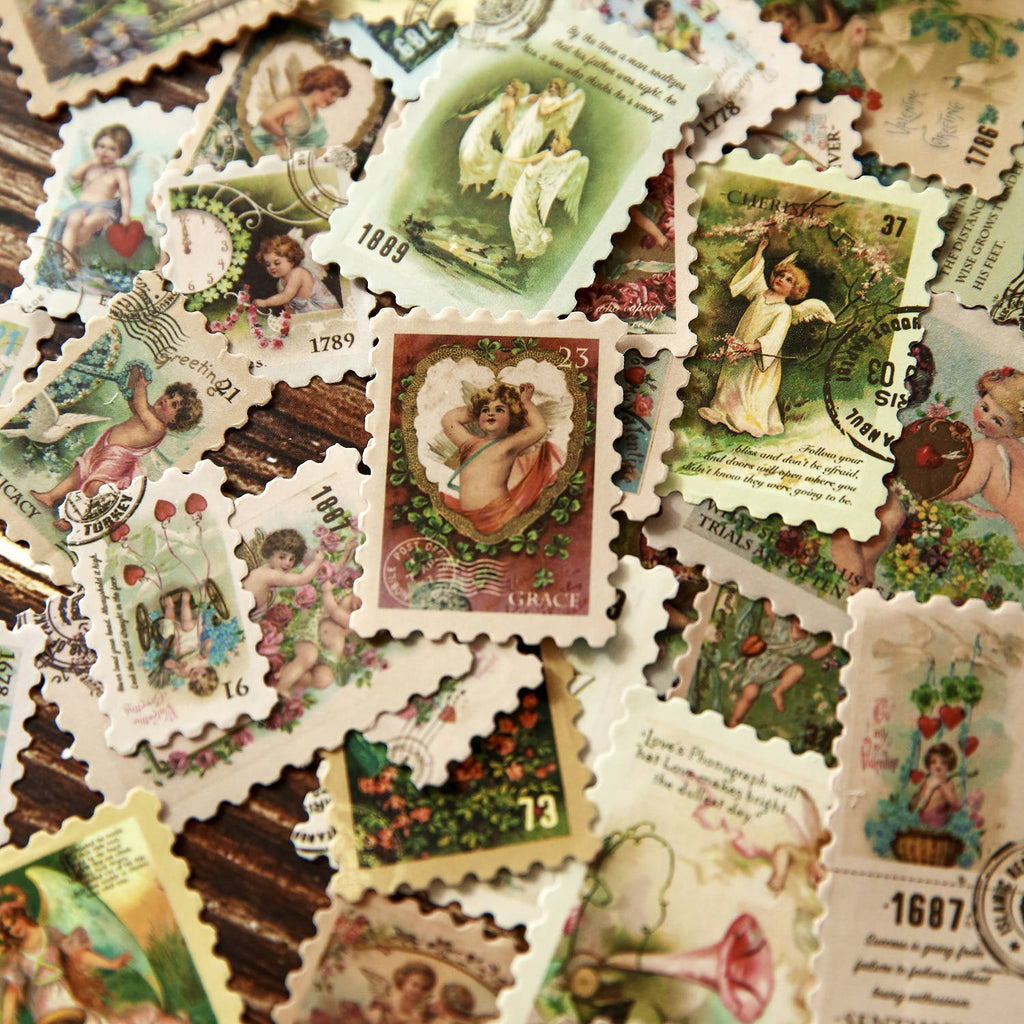 Close-up of vintage postage stamp stickers in sage green – mixed angel and floral motifs with aged postmark borders