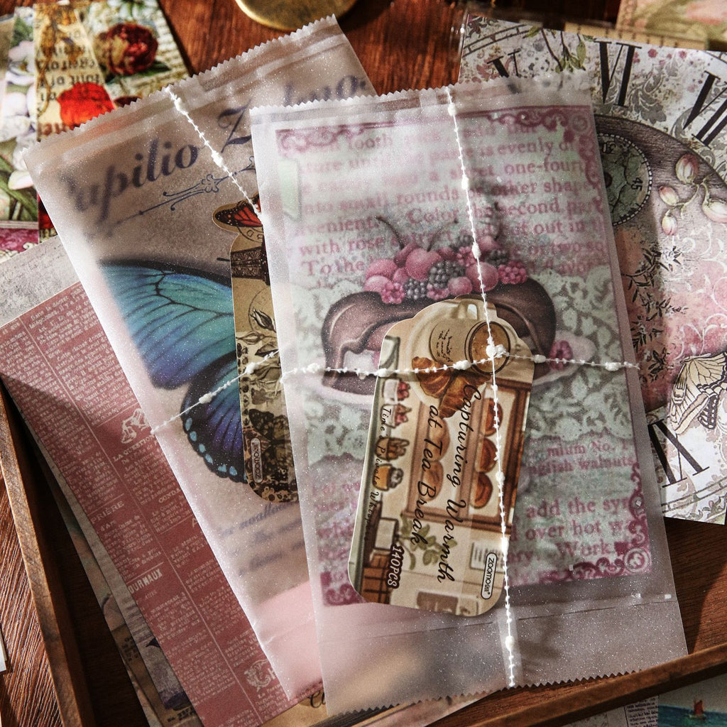 Hand holding the Whispers of Time ephemera pack – 140 mixed pieces of vellum, paper and stickers visible inside